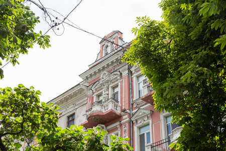 Ukraine, Odessa, Katerynynska Street, 13th of June 2019. Low angle view of a beautiful pink and white building facade with stucco ornamentsのeditorial素材