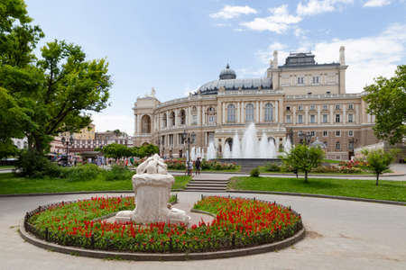 Ukraine, Odessa, 13th of June 2019. Side view of the national academic opera building and the park with the sculpture fountain youth during a sunny dayのeditorial素材