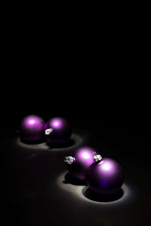 Arrangement of beautiful illuminated purple colored Christmas balls on black backgroundの写真素材