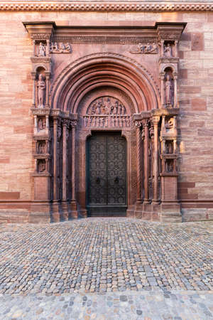Switzerland, Basel, Muensterplatz, 3rd of August 2019. Massive and intricately decorated metal doors and beautiful ornate pillars on the side of the medieval Basel cathedralのeditorial素材