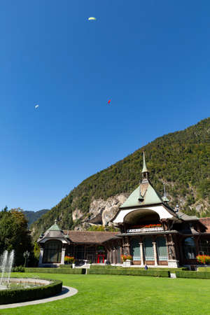 Switzerland, Interlaken, 29 September 2019. View at the historic casino building with paragliders flying in the clear blue sky.のeditorial素材