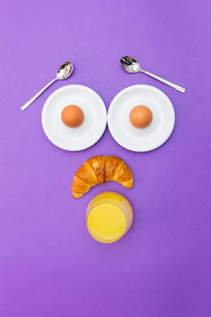 Fun breakfast concept with abstract astonished human face made of breakfast items on purple...