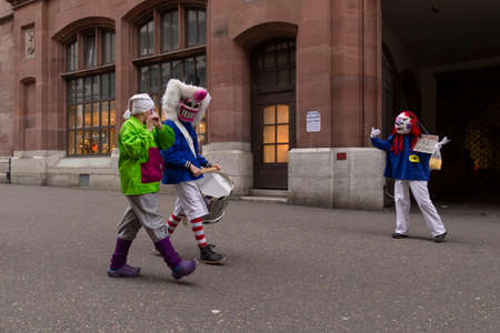 Switzerland, Basel, March 3rd 2020. Basel carnival cancelled due to corona virus pandemic. Small group of participants parading through the otherwise empty street simulating social distancingのeditorial素材