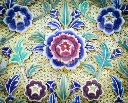 Ceramic carving multi color flower on wall in temple thailand の写真素材