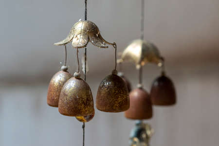 Selective focus Small brass bell hanging in the house golden bell is beautiful. The sound makes the heart calm. Used in Buddhism Christianity Islam.の写真素材