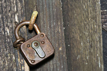 Old padlock on a wooden doorの写真素材