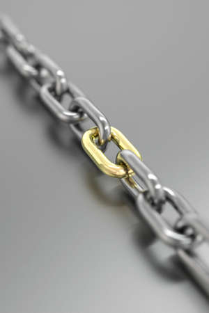 Chain with golden link isolated over a gray background.の写真素材