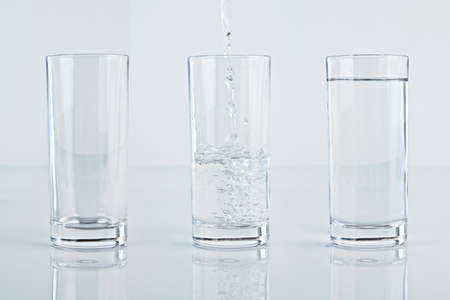 Set of three glass of water over a light blue background, one empty, one full and one with stream of...