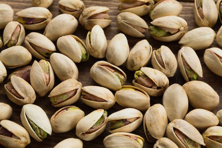 spread of pistachio with shells on wood table