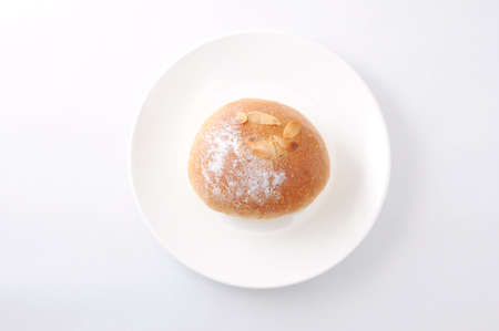butter bread roll on a plate on white backgroundの写真素材
