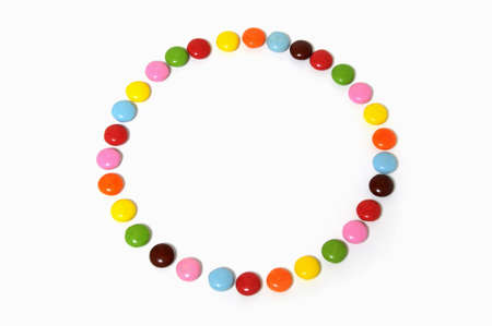 circle of colorful chocolate candies spread on white background