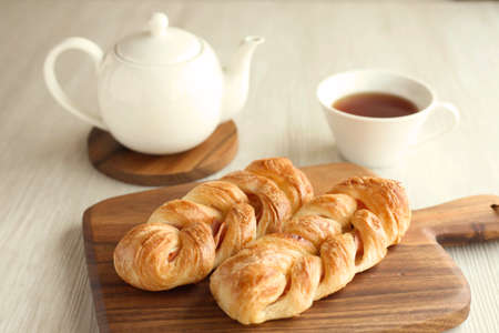 ham danish bread with tea pot and tea cup on table