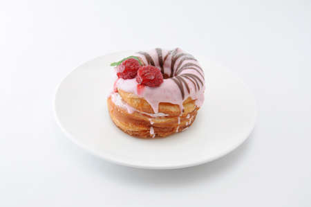 sweet strawberry cake doughnut on a plate on white backgroundの写真素材
