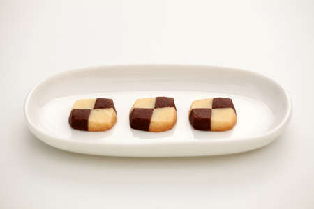 butter milk chocolate cookies biscuits isolated on plate on white backgroundの写真素材