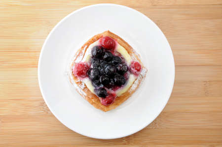 blueberry cake with custard cream on a plate on table