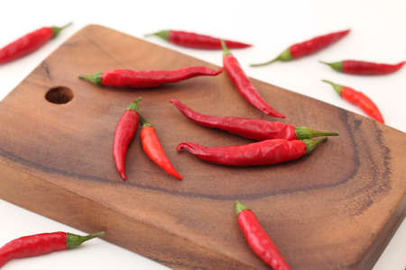 Red chili peppers isolated on a wood cutting board