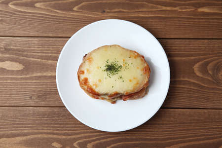 croque monsieur ham cheese sandwich on plate isolated on wooden tableの写真素材