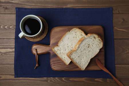 toasted slices of Bread with walnuts on wooden cutting board on table