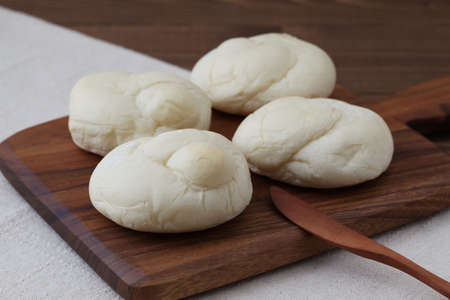 baked white bread on wood cutting board isolated on table