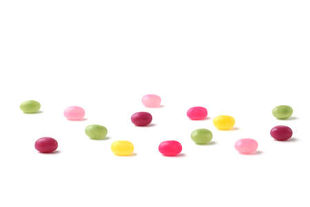 colorful candies jelly beans spread on white backgroundの写真素材