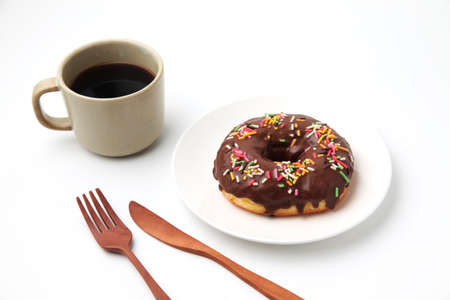 chocolate frosted doughnut on plate with hot coffee on white background