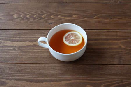 cup of tea with sliced lemon isolated on wooden tableの写真素材