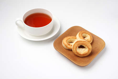 ring scone biscuit on plate with hot tea isolated on white backgroundの写真素材