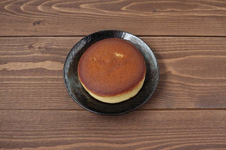 dorayaki japanese traditional pancake isolated on plate on wooden tableの写真素材
