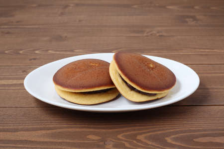 dorayaki japanese traditional pancake isolated on plate on wooden tableの写真素材