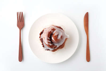 cinnamon roll bread on plate closeup isolated on white backgroundの写真素材