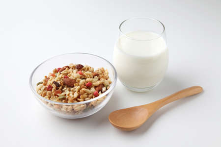 granola cereal in bowl with milk closeup isolated on white background