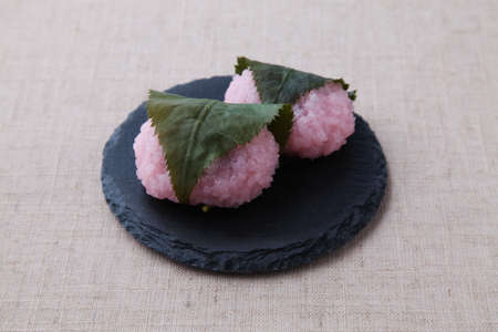 sakura mochi rice cake Japanese confectionery on plate isolated on table clothの写真素材
