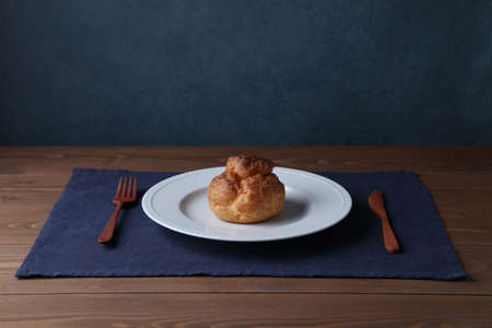 cream puff on plate closeup isolated on wooden tableの写真素材