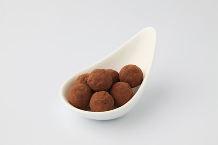 chocolate truffles on plate closeup on white backgroundの写真素材