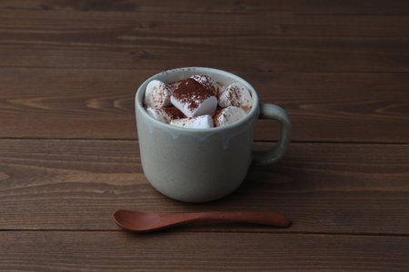 hot chocolate with marshmallows isolated on wooden tableの写真素材