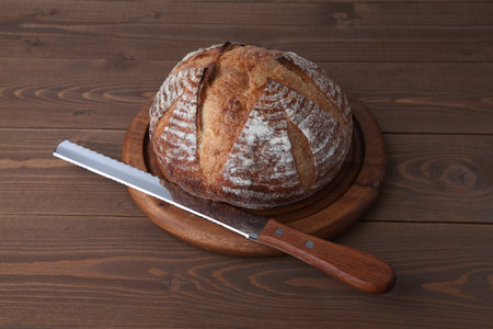 pain de campagne french bread with bread knife isolated on wooden table