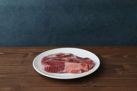 raw pork meat isolated on wooden tableの写真素材