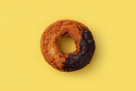 old fashioned doughnut chocolate closeup isolated on yellow backgroundの写真素材