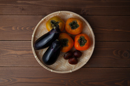 eggplant persimmon chestnuts assorted platter isolated on wooden table