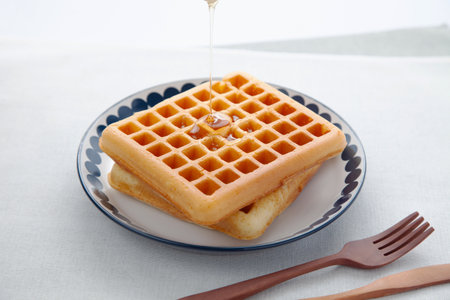 waffles pancakes with maple syrup on plate on tableの写真素材