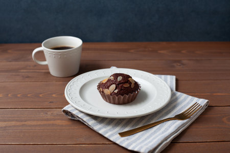 chocolate cupcake muffin with coffee isolated on wooden tableの写真素材