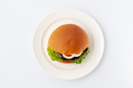 teriyaki hamburger with boiled egg on plate isolated on white backgroundの写真素材