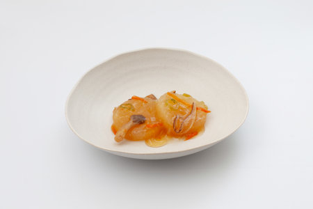 simmered Japanese radish with mushroom sauce on white backgroundの写真素材