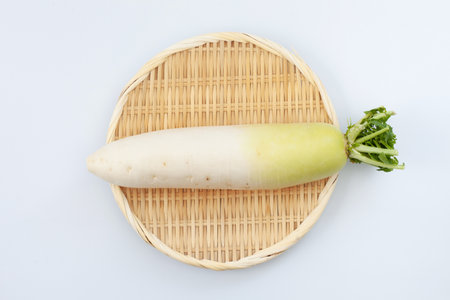 Japanese white radish on bamboo strainer on white backgroundの写真素材