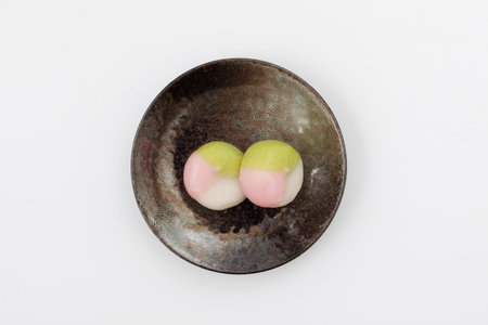 three colored dumpling rice cake Japanese confectionery on plate on white backgroundの写真素材