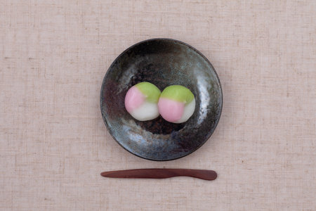 three colored dumpling rice cake Japanese confectionery on plate on table clothの写真素材