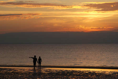 A couple on a beach at duskの写真素材
