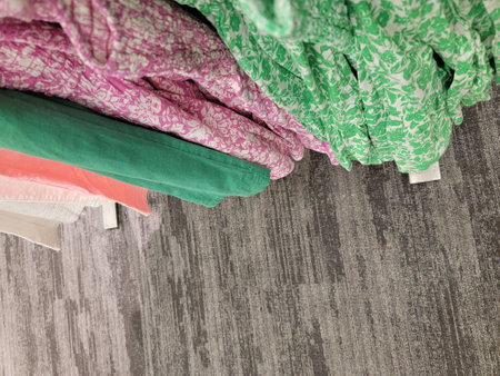 Colorful clothes hanging on clothesline on grey carpet background