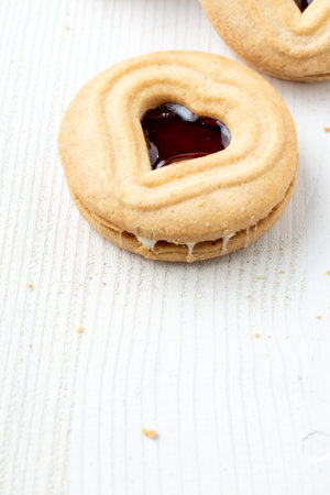 Top view of heart-shaped cookie and strawberry jam, on white table, for Valentine's Day, vertical, with copy spaceの写真素材