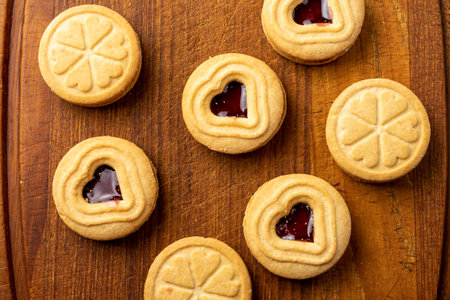 Aerial view of heart shaped cookies with strawberry jam, selective focus, on wooden board, horizontalの写真素材